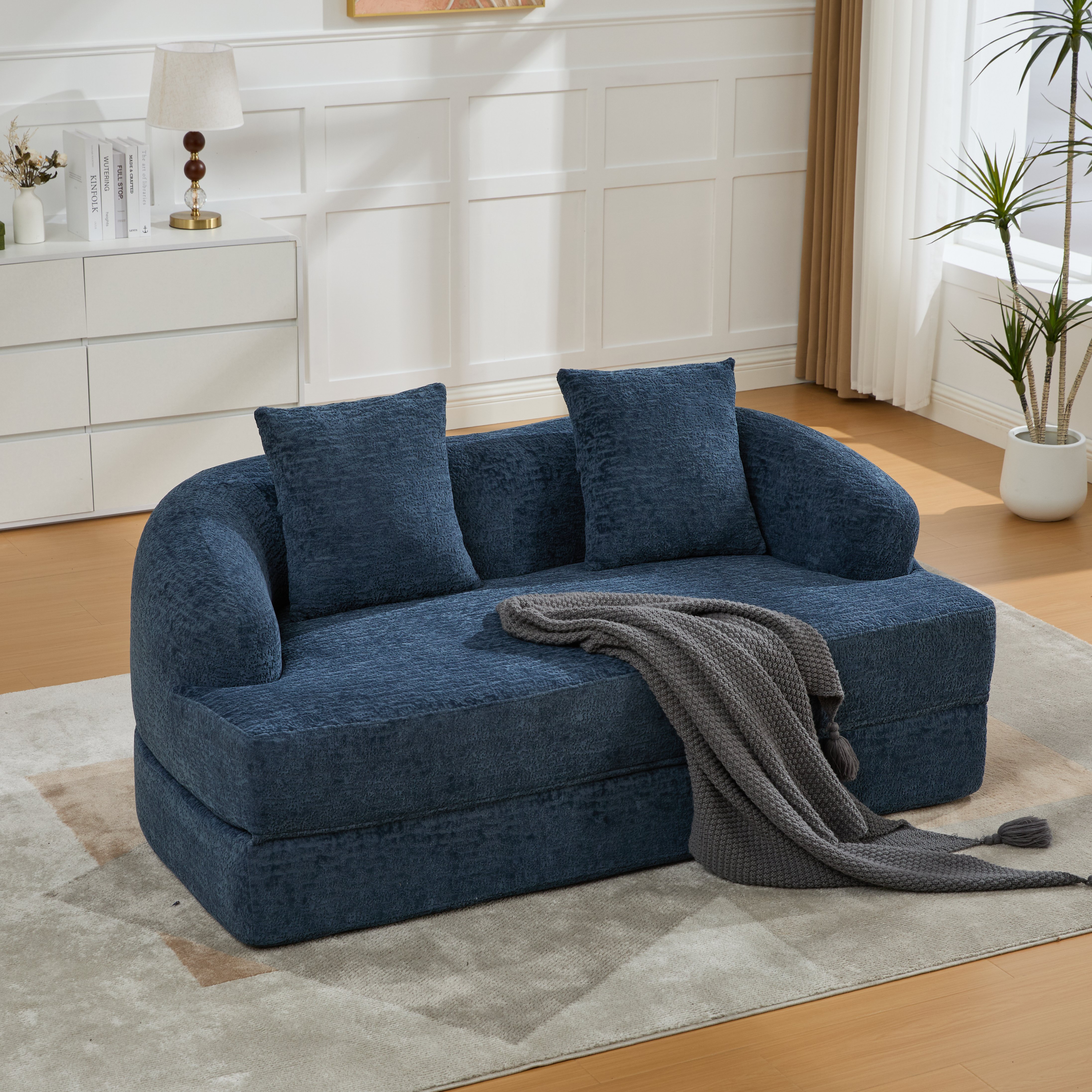 Canapé-lit 2 places bleu marine en chenille avec deux coussins et rangement intégré pour petit salon