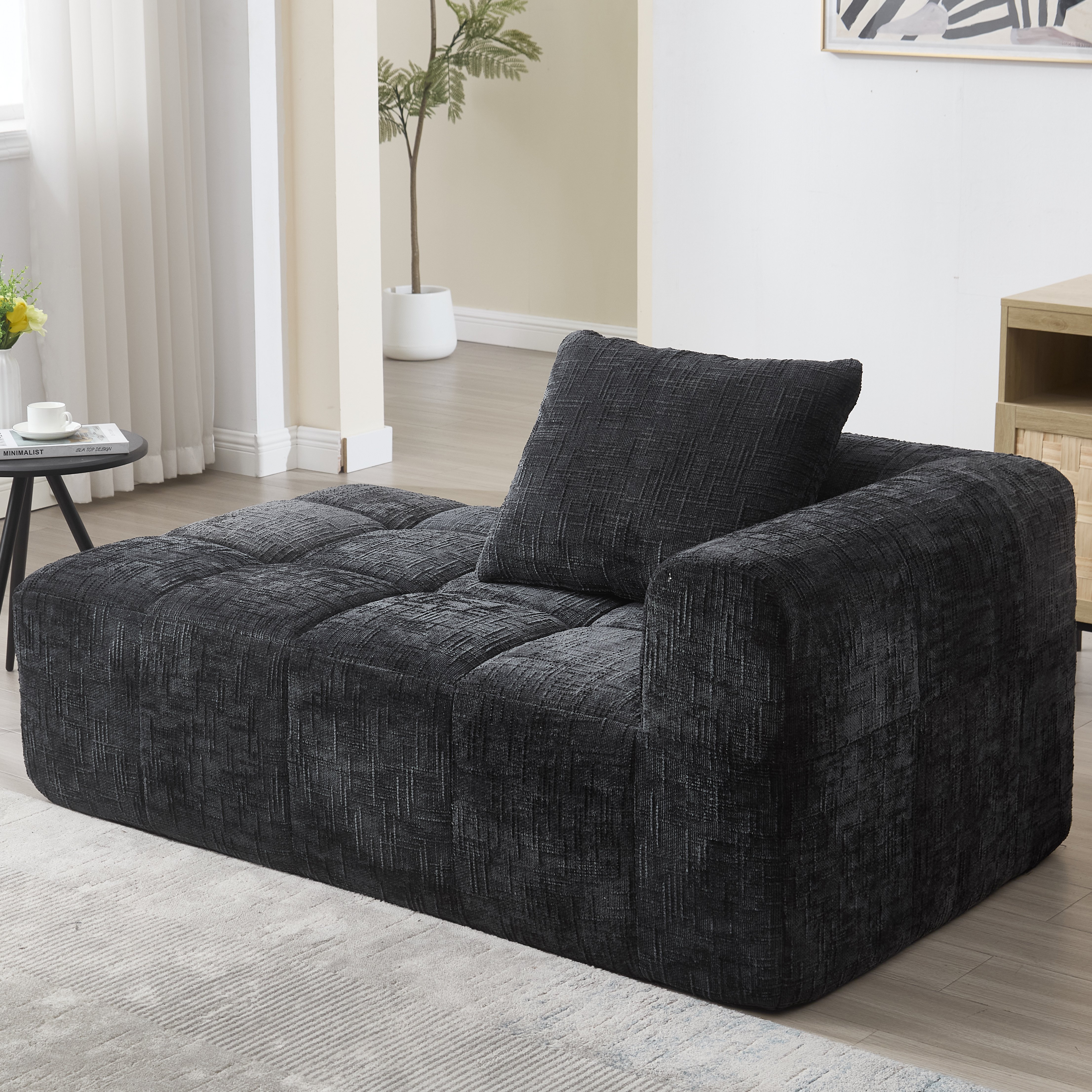 Canapé noir en chenille avec méridienne, coussin inclus et poches latérales pratiques pour salon