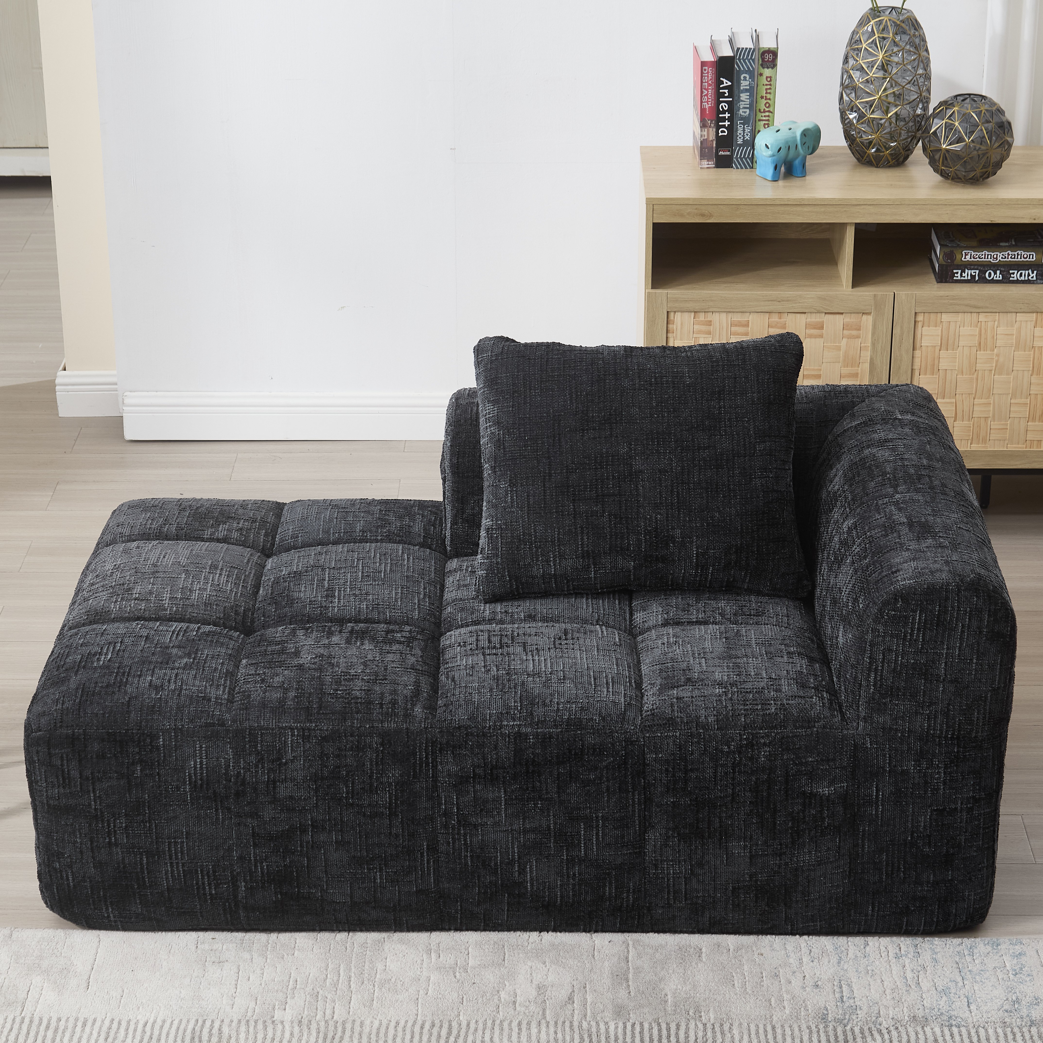 Canapé noir en chenille avec méridienne, coussin inclus et poches latérales pratiques pour salon