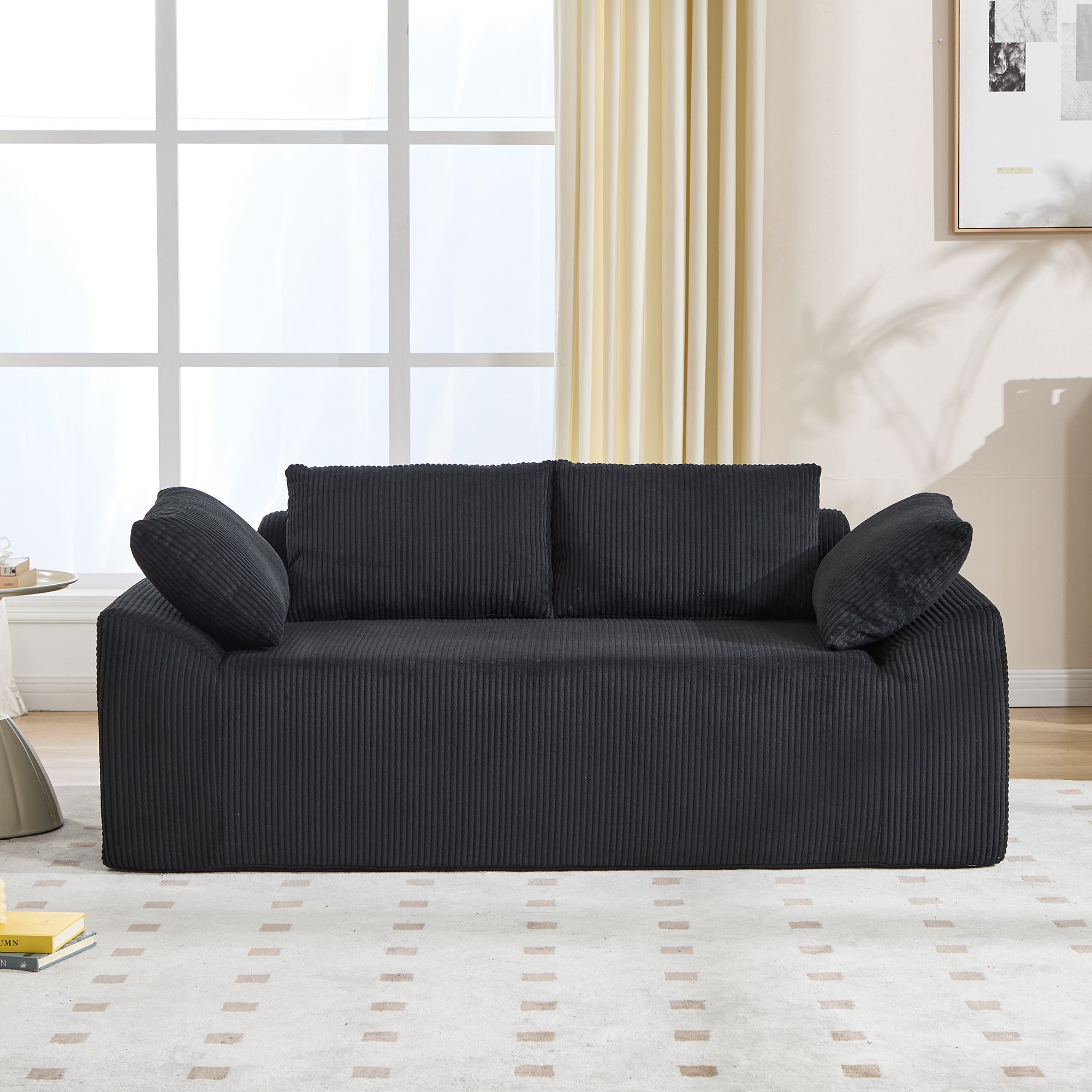 Canapé sans structure noir en tissu avec mousse à mémoire de forme, assise profonde et accoudoirs courbés, idéal pour petits espaces